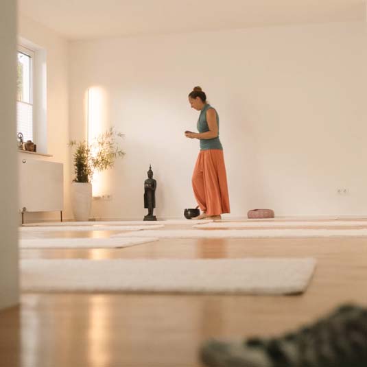 Yogalehrerin Gabriele zündet im Yoga Studio JAZUYOGA eine Kerze an – ruhiger Beginn der Hatha-Yogapraxis