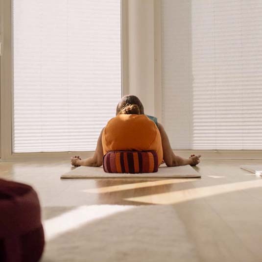 Tiefenentspannung im Hatha Yoga – Yogalehrerin Gabriele ruht im Yoga Studio auf Kissen